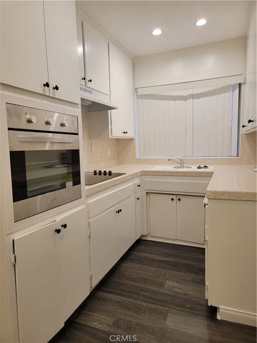 a kitchen with cabinets appliances and a window