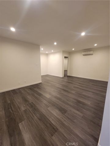 an empty room with wooden floor and entrance