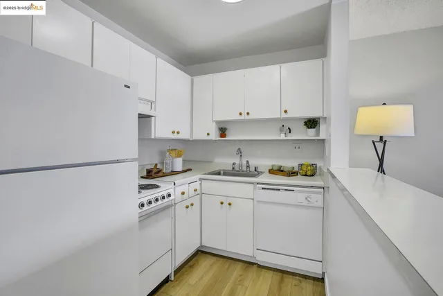 a kitchen with granite countertop white cabinets and white appliances