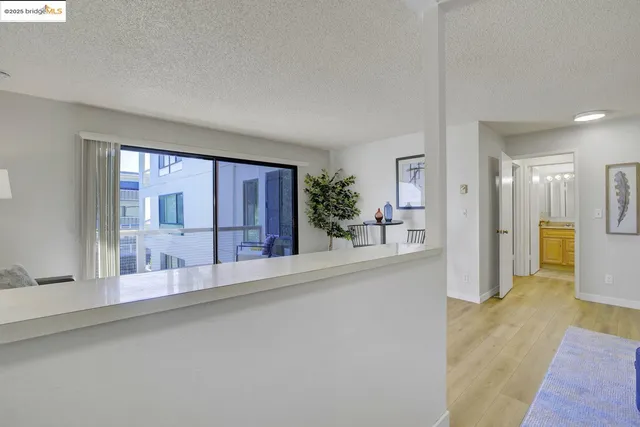 a view of a living room with a large window and wooden floor