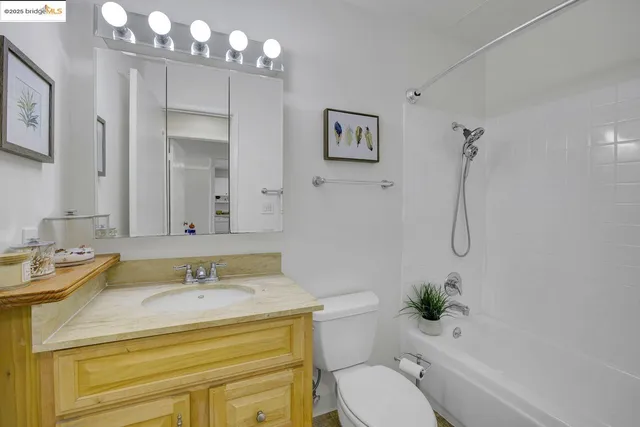a bathroom with a granite countertop sink a toilet and shower