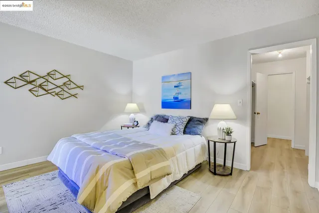 a bedroom with a bed and painting on the wall