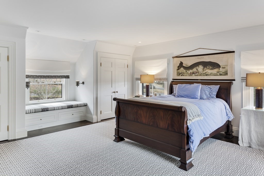235 Nashawtuc Road Concord, MA 01742 - Photo 17 of 26 a spacious bedroom with a bed and a painting on the wall