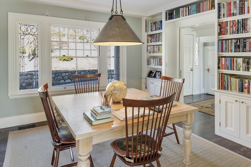 235 Nashawtuc Road Concord, MA 01742 - Photo 10 of 26 a dining room with furniture a book shelves and wooden floor