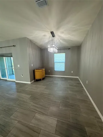 a view of empty room with wooden floor and window
