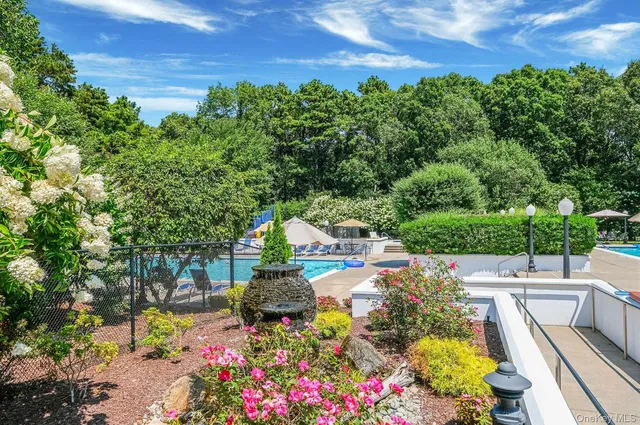 a view of yard with swimming pool and green space