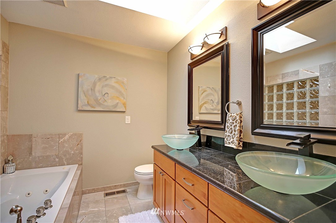 609 213th Street Southwest Bothell, WA 98021 - Photo 12 of 31 a bathroom with a granite countertop sink and a large mirror