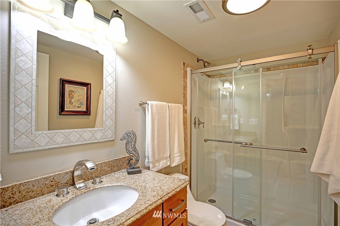 609 213th Street Southwest Bothell, WA 98021 - Photo 23 of 31 a bathroom with a granite countertop sink toilet and shower