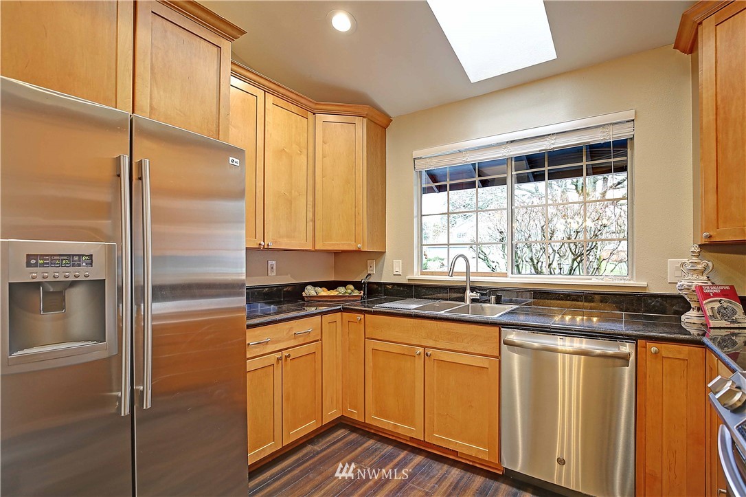 609 213th Street Southwest Bothell, WA 98021 - Photo 7 of 31 a kitchen with granite countertop stainless steel appliances a sink window and cabinets