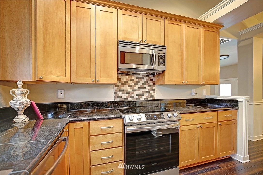 609 213th Street Southwest Bothell, WA 98021 - Photo 9 of 31 a kitchen with stainless steel appliances granite countertop a stove and a microwave