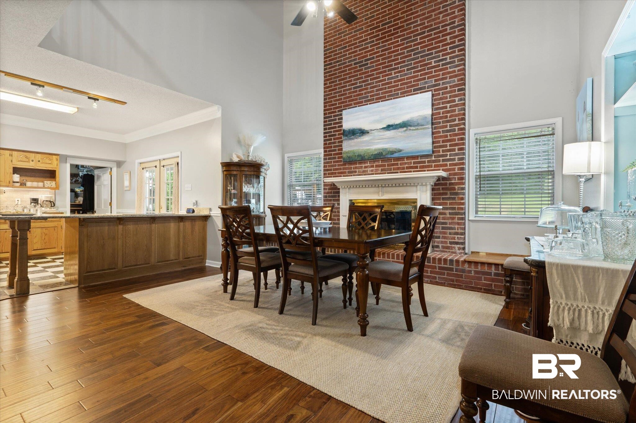 2300 Radcliff Road Saraland, AL 36571 - Photo 10 of 56 Dining room with a high ceiling, wood finished floors, a brick fireplace, a ceiling fan, and crown molding