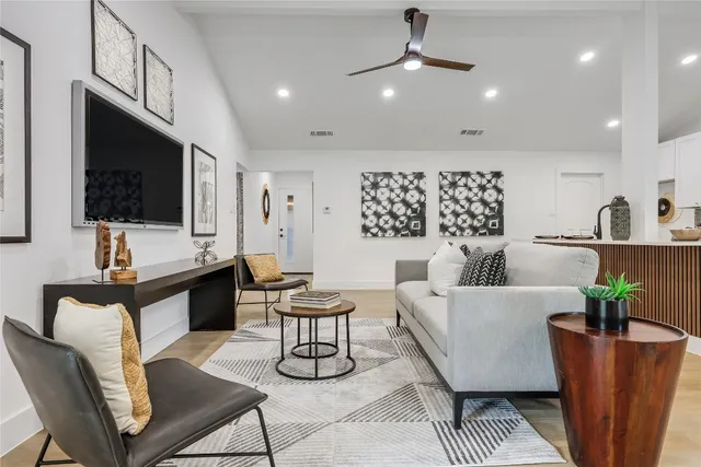 a living room with furniture a flat screen tv and a chandelier