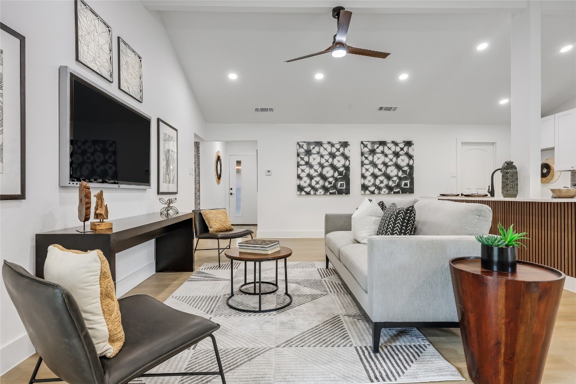 a living room with furniture a flat screen tv and a chandelier