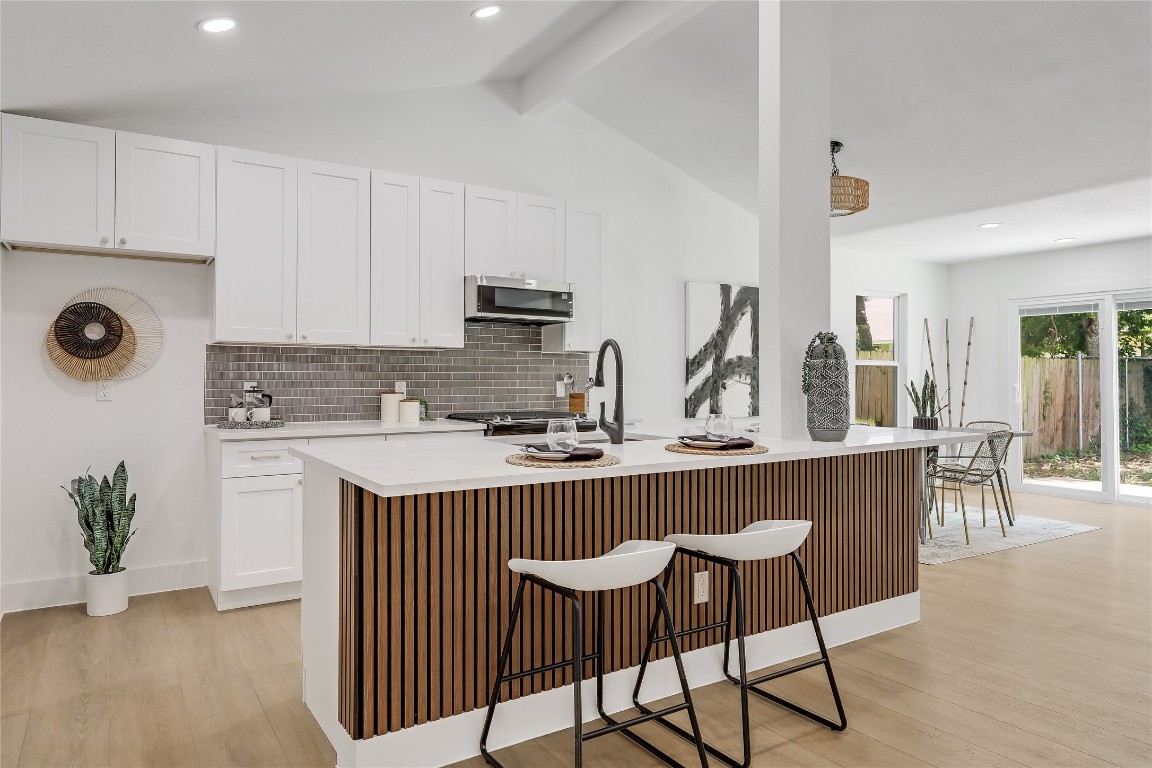 12208 Double Tree Lane Austin, TX 78750 - Photo 18 of 35 a kitchen with stainless steel appliances granite countertop a table chairs sink and cabinets