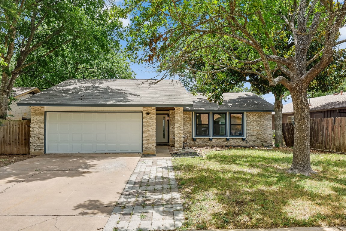 12208 Double Tree Lane Austin, TX 78750 - Photo 2 of 35 a front view of a house with a garden and yard