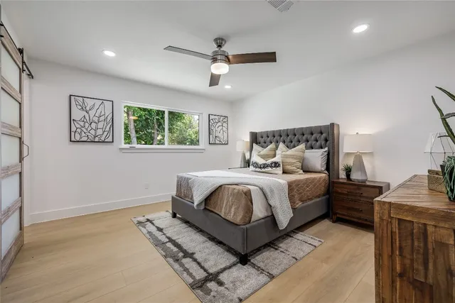 a bed sitting in a spacious bedroom next to a window