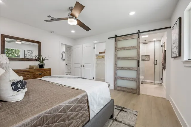 a spacious bedroom with a bed and a chandelier