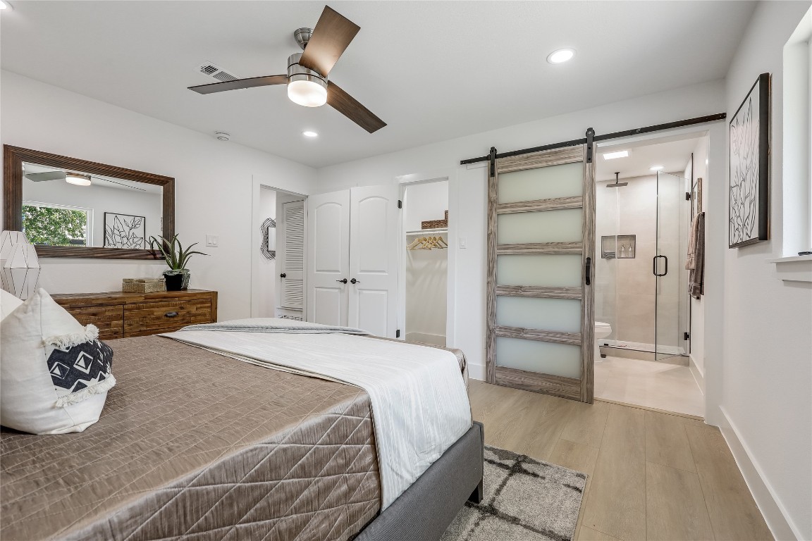 12208 Double Tree Lane Austin, TX 78750 - Photo 29 of 35 a spacious bedroom with a bed and a chandelier