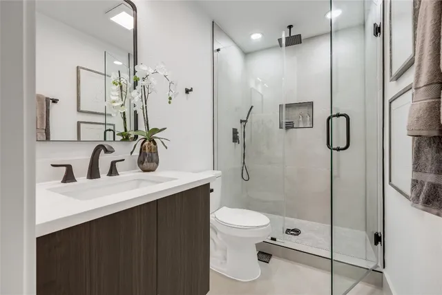 a bathroom with a granite countertop sink toilet and shower