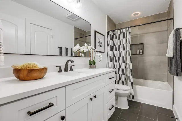 a bathroom with a granite countertop sink a toilet and shower