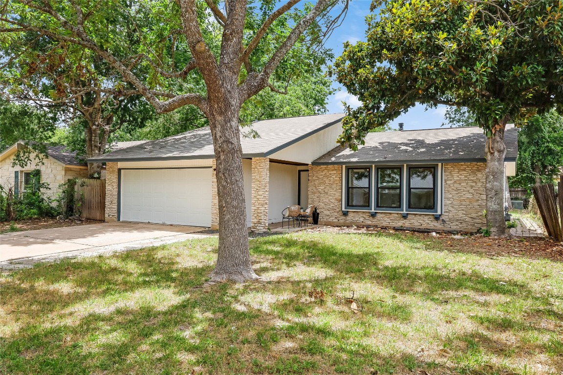 12208 Double Tree Lane Austin, TX 78750 - Photo 35 of 35 a backyard of a house with table and chairs under an umbrella