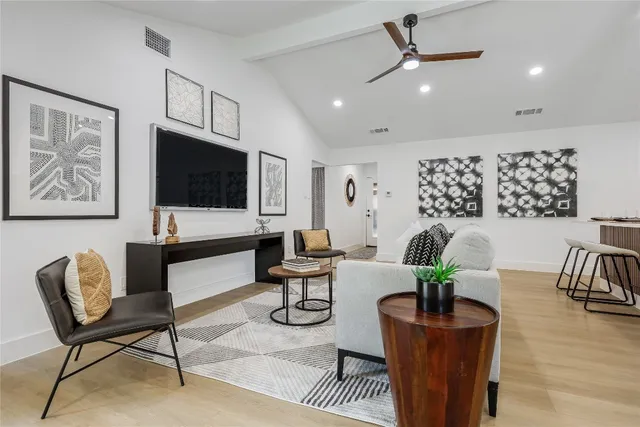 a living room with furniture a flat screen tv and potted plant