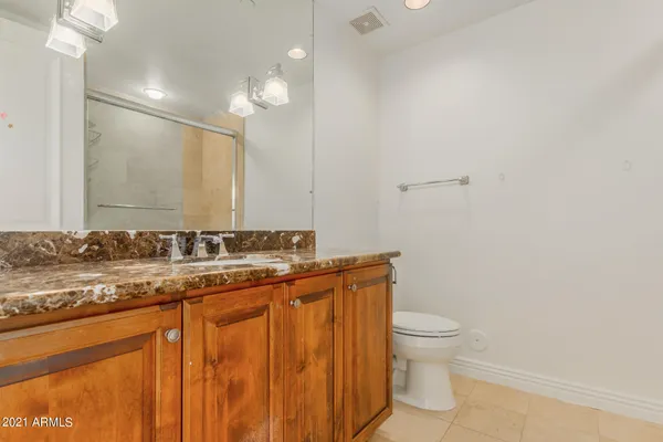a bathroom with a granite countertop sink a toilet and a mirror