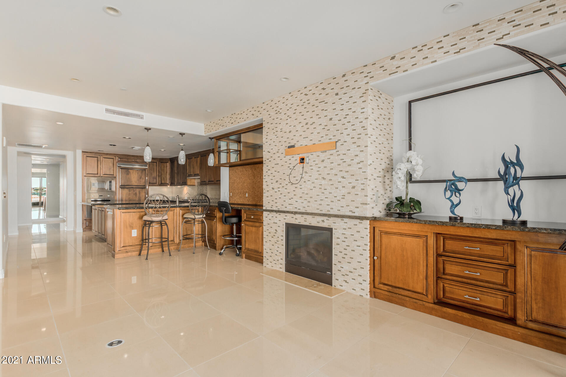 7175 East Camelback Road, Unit 707 Scottsdale, AZ 85251 - Photo 5 of 31 a kitchen with stainless steel appliances granite countertop a stove top oven a sink a dining table and chairs with wooden floor