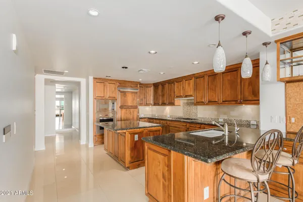 a kitchen with stainless steel appliances granite countertop a sink and a refrigerator