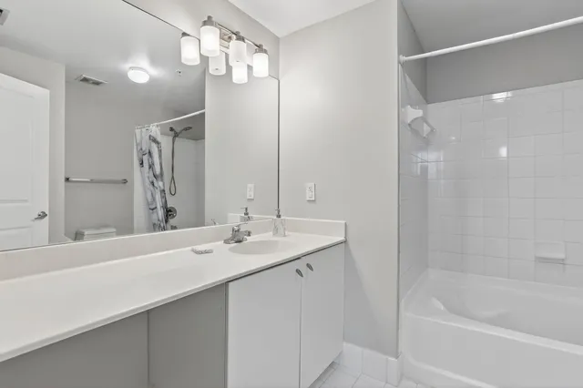 a bathroom with a bath tub sink and mirror