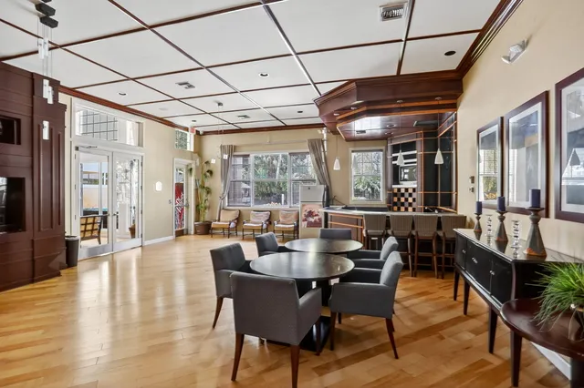 a front view of a building with a garden and trees