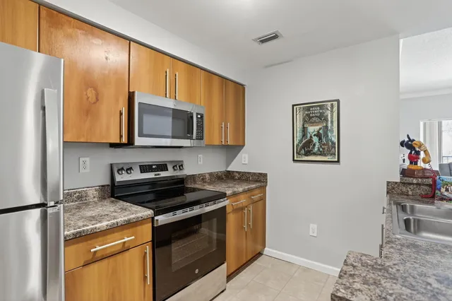 a kitchen with stainless steel appliances granite countertop a stove a refrigerator and a microwave