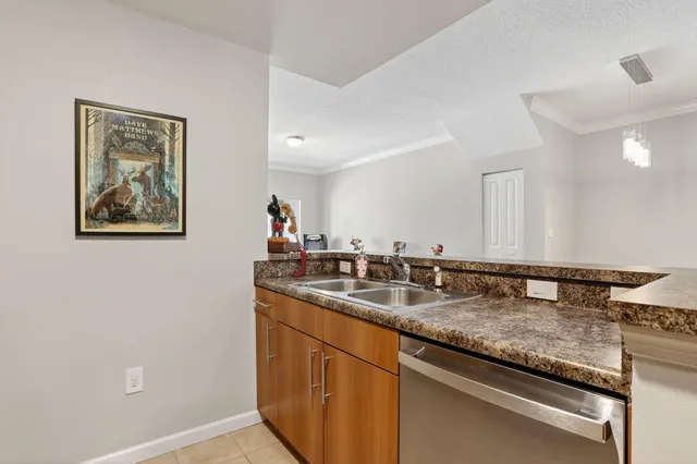 a kitchen with granite countertop a sink a stove and cabinets