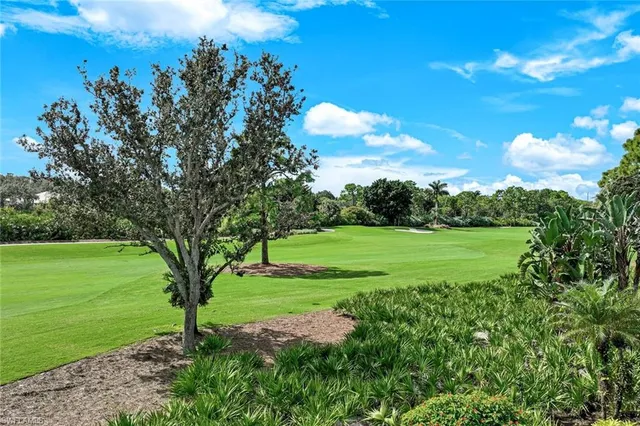 a front view of a house with a yard and potted plants