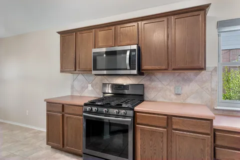 a kitchen with granite countertop a stove and a microwave