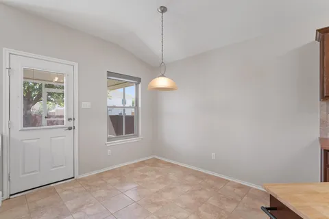 a view of an empty room with window and cabinet