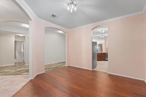 wooden floor in an empty room with a chandelier