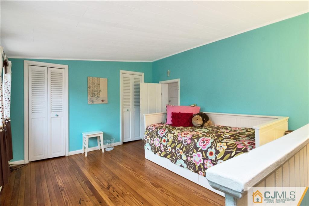 19 Reids Hill Road Morganville, NJ 07751 - Photo 15 of 24 a bed sitting in a bedroom next to a window with wooden floor