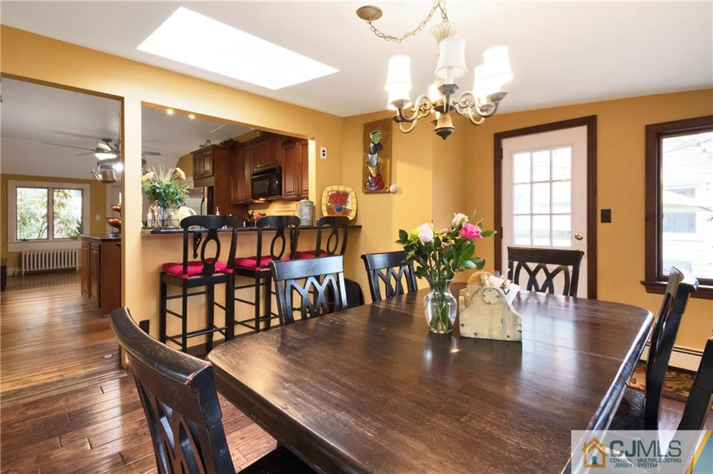 19 Reids Hill Road Morganville, NJ 07751 - Photo 8 of 24 a view of a dining room and livingroom with furniture wooden floor a chandelier