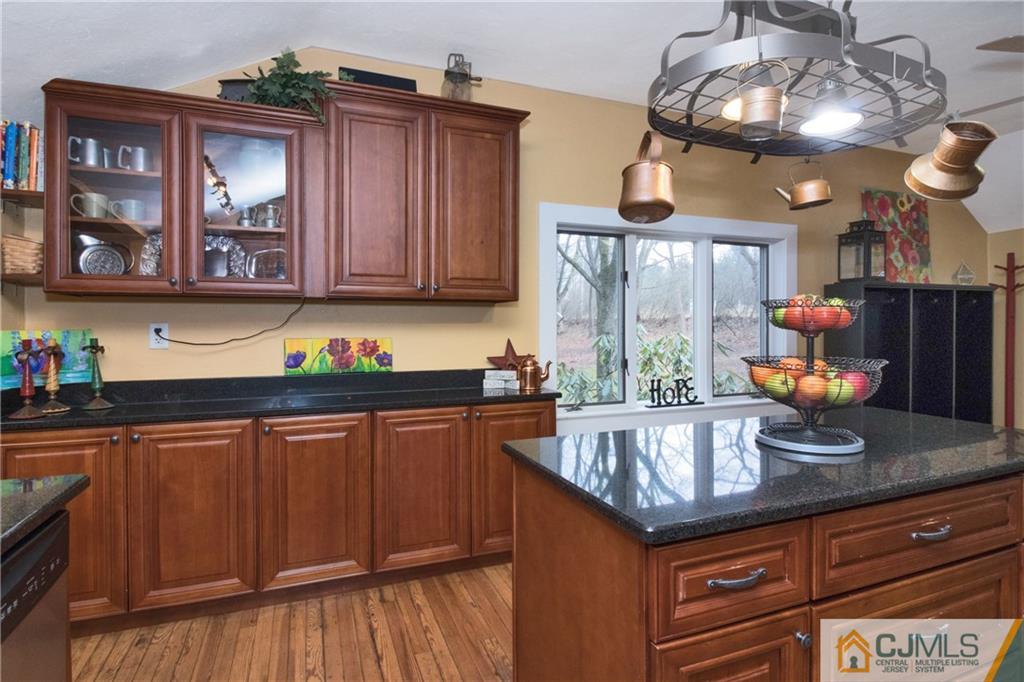 19 Reids Hill Road Morganville, NJ 07751 - Photo 9 of 24 a kitchen with stainless steel appliances granite countertop a sink dishwasher and cabinets with wooden floor