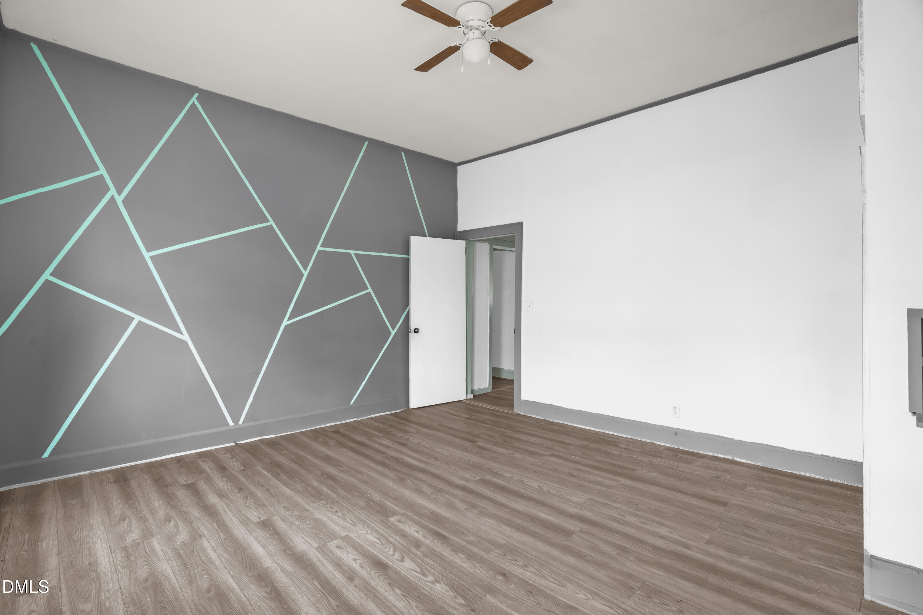 201 East H Street Erwin, NC 28339 - Photo 16 of 23 an empty room with wooden floor and a ceiling fan