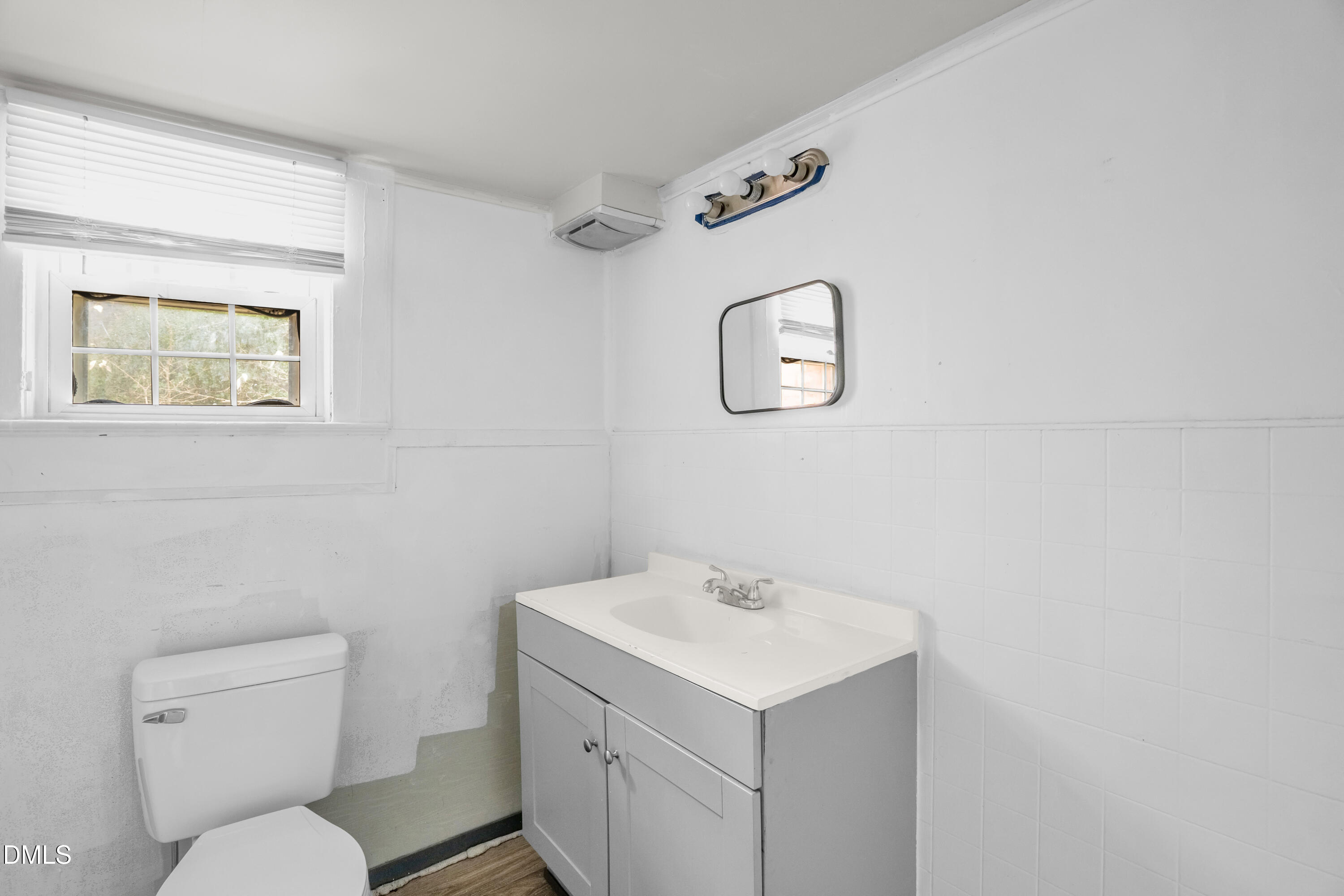 201 East H Street Erwin, NC 28339 - Photo 17 of 23 a bathroom with a toilet sink vanity and mirror