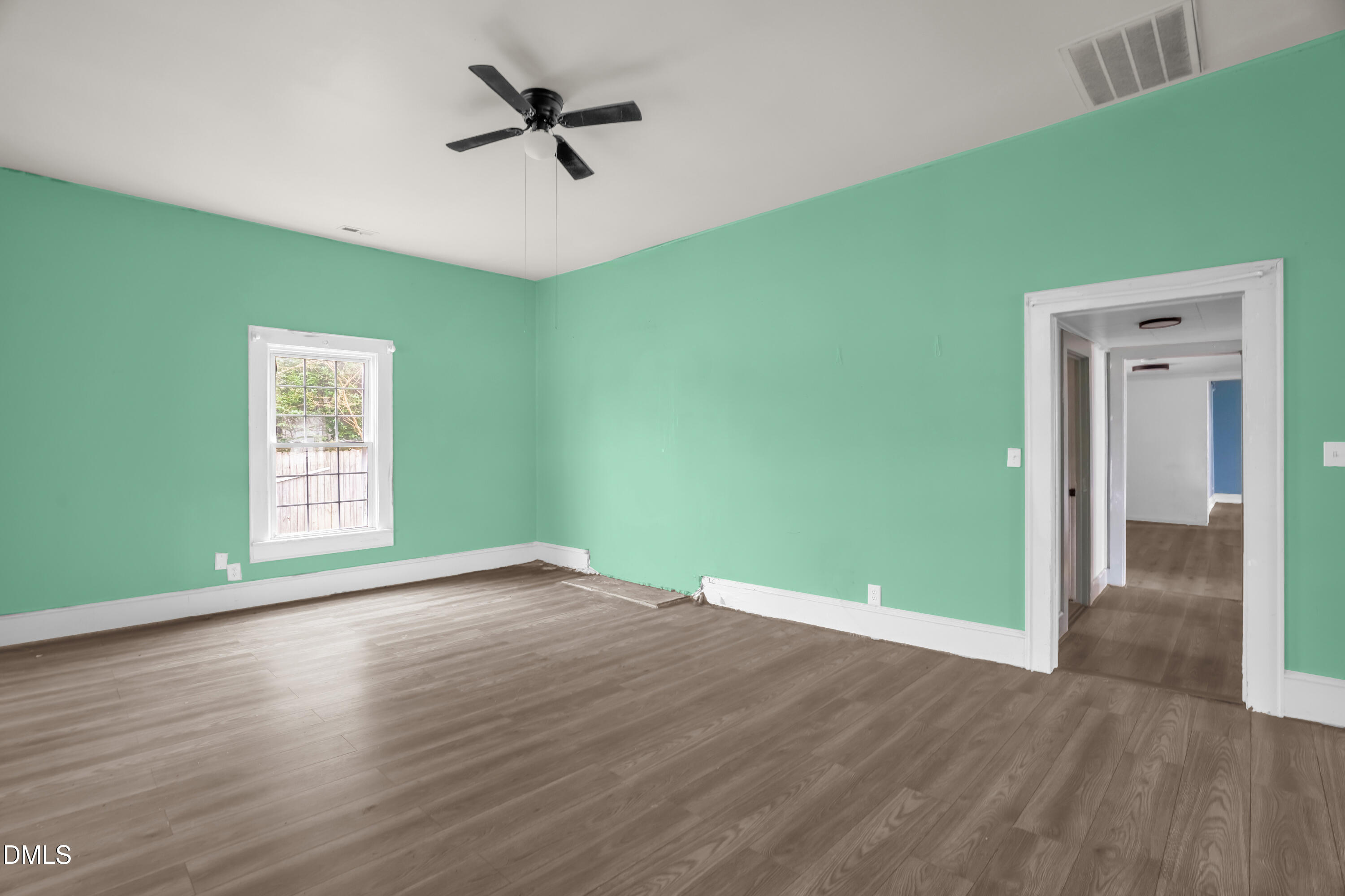 201 East H Street Erwin, NC 28339 - Photo 4 of 23 a view of a big room with wooden floor a ceiling fan and windows