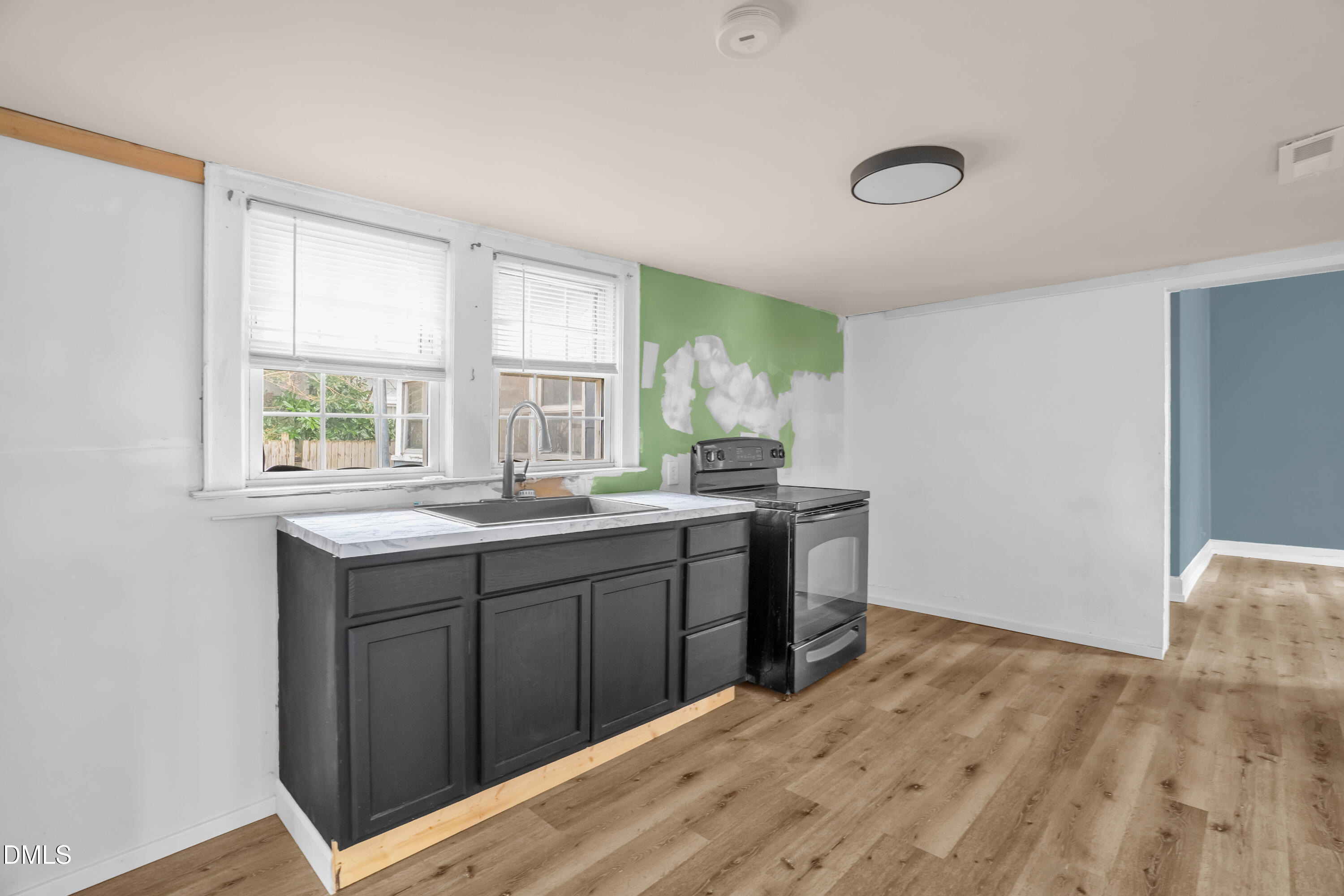 201 East H Street Erwin, NC 28339 - Photo 8 of 23 a kitchen with granite countertop a sink cabinets and wooden floor