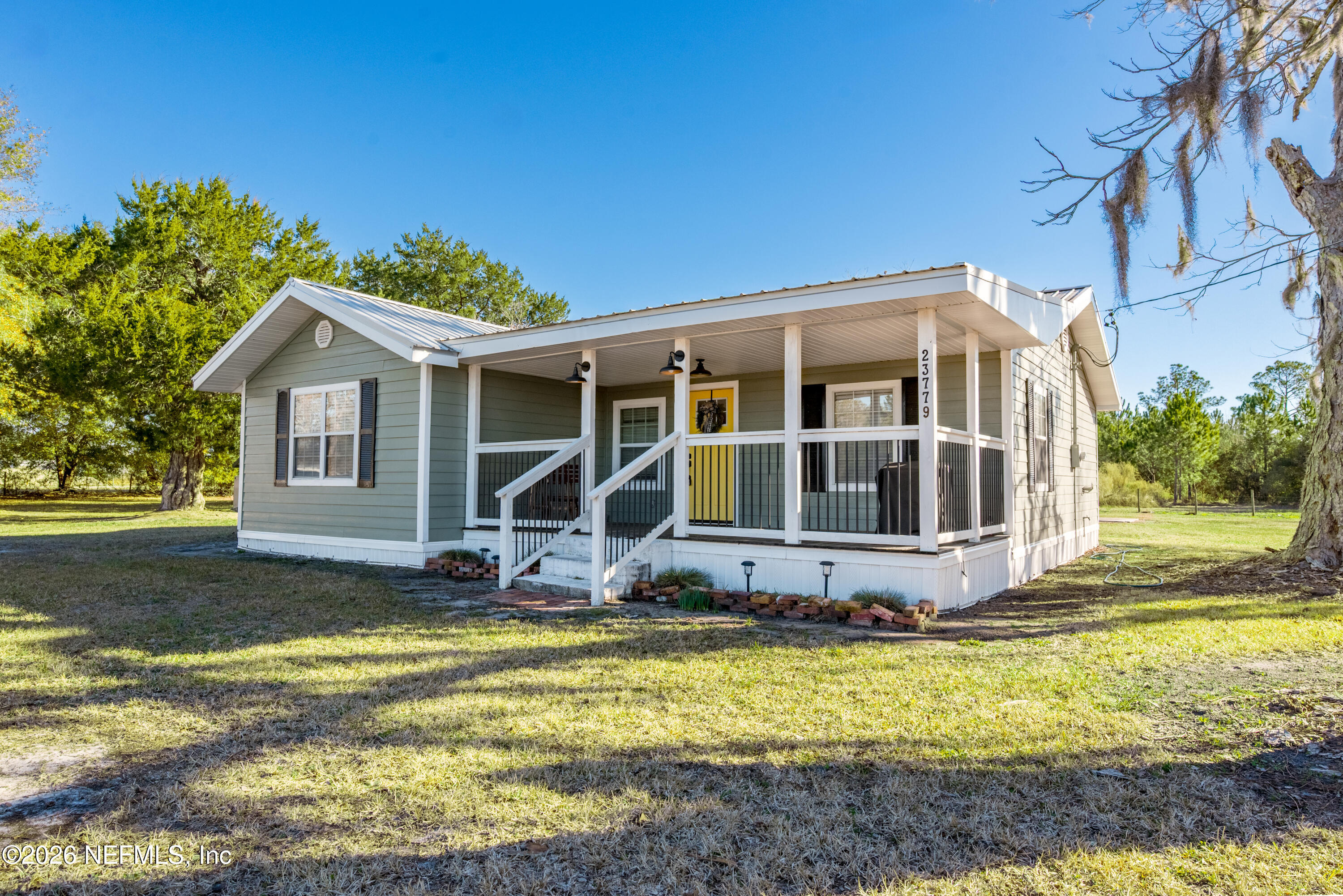 23779 Northwest 225a Road, Unit COUNTY Starke, FL 32091 - Photo 2 of 73 a front view of a house with yard and trees in the background