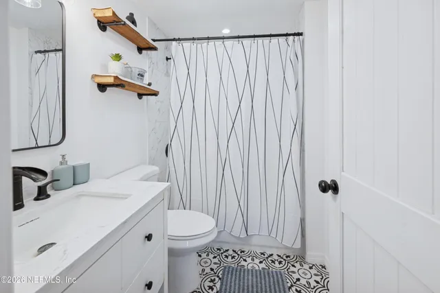 a bathroom with a toilet and a shower curtain