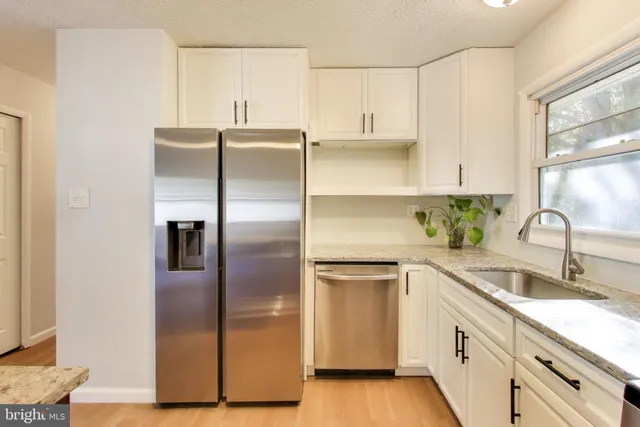 a kitchen with stainless steel appliances a refrigerator sink and cabinets