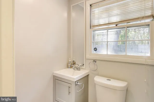 a bathroom with a sink a toilet and a window