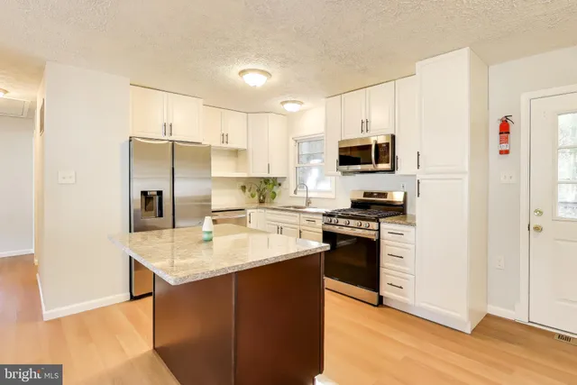 a kitchen with stainless steel appliances granite countertop a stove refrigerator sink and dishwasher