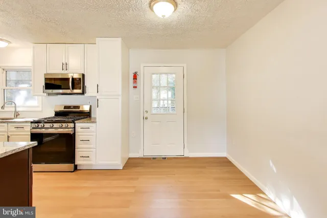 a kitchen with stainless steel appliances a stove microwave and refrigerator
